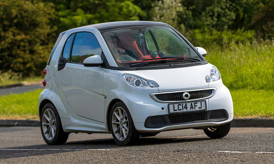 Stony Stratford,UK - June 4th 2023: 2014 white SMART (MCC) FORTWO     classic car travelling on an English country road.