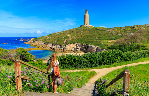 Woman tourist enjoying beautiful view of Hercules tower, A Coruna, Galicia in Spain