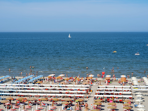 Riccione, Italy. Aerial view of colorful beach umbrellas, gazebos and sun beds at Italian sandy beaches. Adriatic coast. Emilia Romagna region. Summer holidays at the sea