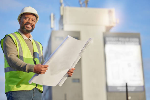 istock Portrait, black man and engineer with blueprints, outdoor and innovation for construction site, building and smile. Face, African male employee and architect with document, paperwork and contractor 1496171619