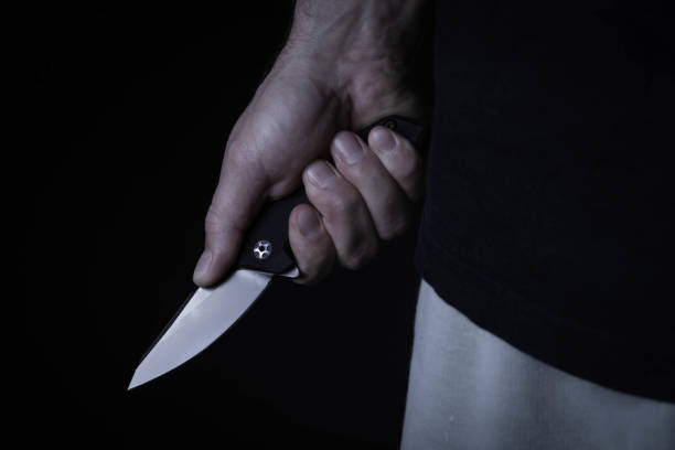 istock A sharp knife in the man's hand. The use of cold weapons. Knife attack . Armed raid. 1496171654