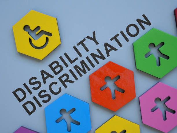 Small colorful figurines and inscription disability discrimination. stock photo