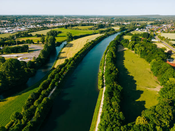 istock Summer aerial drone view landscape navigable river with bridges, agricultural fields and forests and farmers houses in Germany countryside. 1496174700
