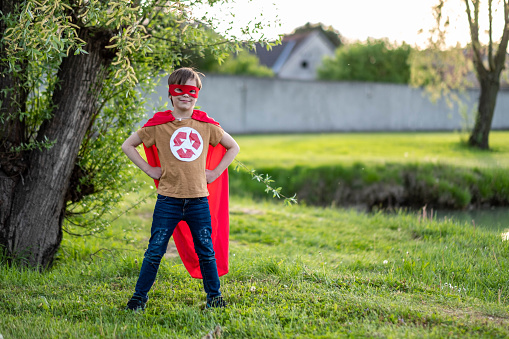 portrait of a happy boy standing on the grass in a recycling costume