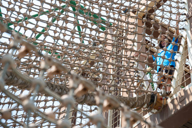 istock Little boy in ropes course in outdoors free public adventure park 1496176092