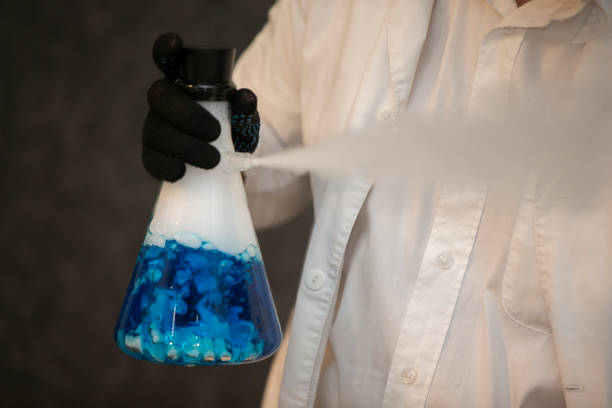istock Chemical flask with a blue solution in the hands of a laboratory assistant. Experiences and experiments. 1496178016
