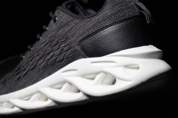 istock Black fabric sneakers with a white sole on a black background. 1496178393