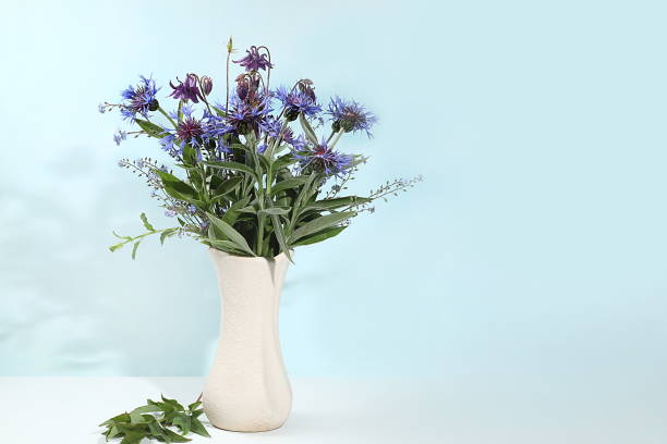 istock Home interior with decor elements, beautiful wild wildflowers bluebell in a vase on a light background, abstract flower composition 1496179467