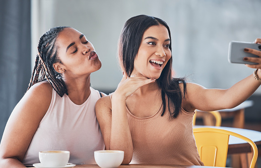 Women friends, coffee shop and smartphone for selfie, happy or solidarity with beauty on social network. Gen z black woman, phone and relax in cafe for blog, profile picture or photography on web app