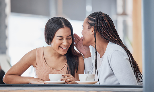 Talking, laughing and friends at a cafe for coffee, gossip and sharing secrets. Smile, conversation and women speaking, chatting and relaxing with tea, funny jokes and friendship in a restaurant