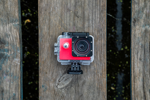 Action camera in a protective box on a wooden background.