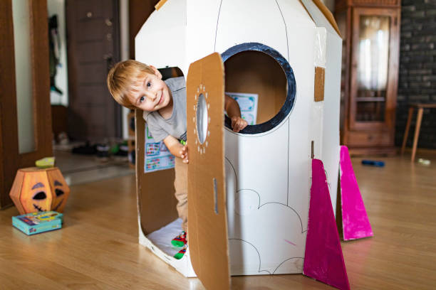 istock Little boy playing in DIY cardboard rocket 1496182904