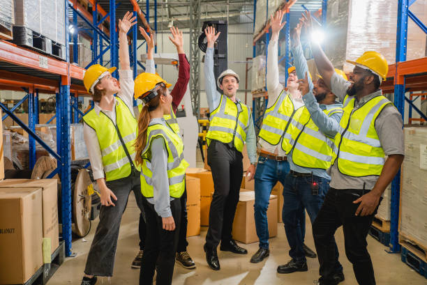 istock Group of happy warehouse workers celebrating success in warehouse 1496183079