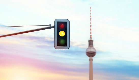 Traffic light against the sunset sky and TV tower