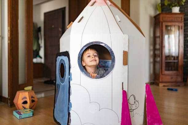 istock Little boy playing in DIY cardboard rocket 1496184308