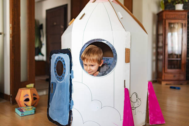 istock Little boy playing in DIY cardboard rocket 1496184312