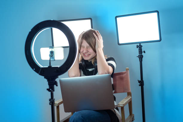 istock Influencer making video with ring light, smartphone, laptop, color background 1496185816