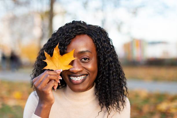 istock Young Black female portrait with yellow autumn maple leaf 1496186564