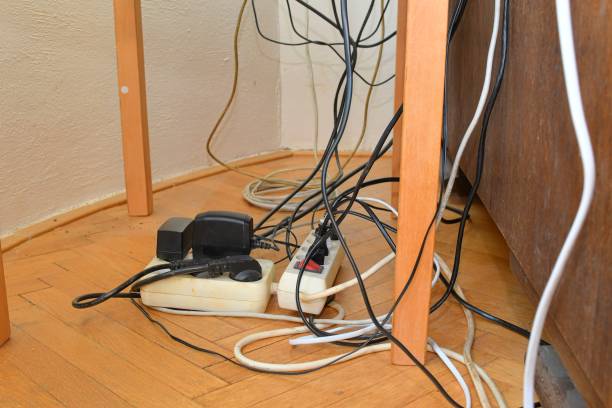 istock Tangled cables in the extension cord. Messy cables. Cables tangled on parquet flooring. 1496187511