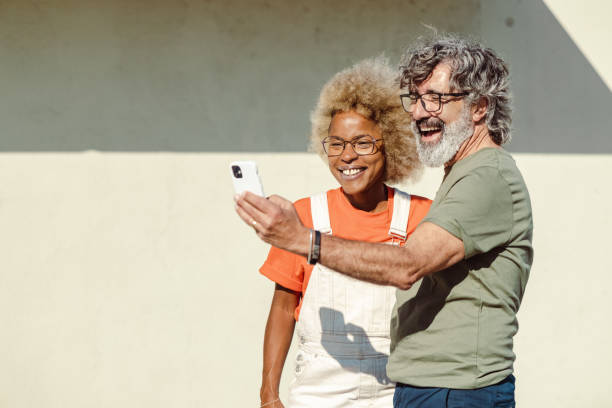istock Modern good looking people using smart phone and taking selfie in the city 1496188068