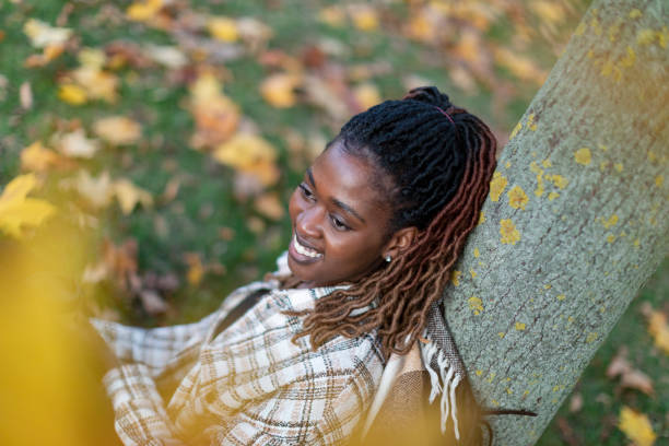 istock Black woman relaxing at autumn park alone 1496188131