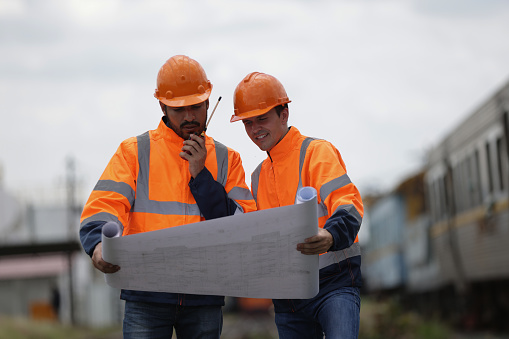 Architecture, construction building with an architect,  railway engineer and designer working as a team and reading a blueprint. Teamwork, collaboration and development with a group of creative staff