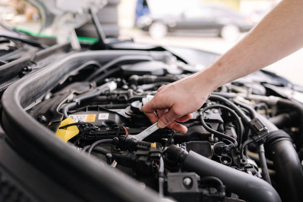 istock Auto mechanic working in garage. Human hands hold tools. Repair service concept 1496188964