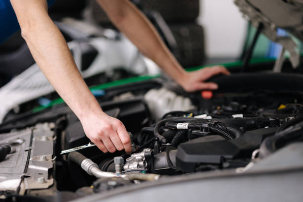 istock Auto mechanic working in garage. Human hands hold tools. Repair service concept 1496189567