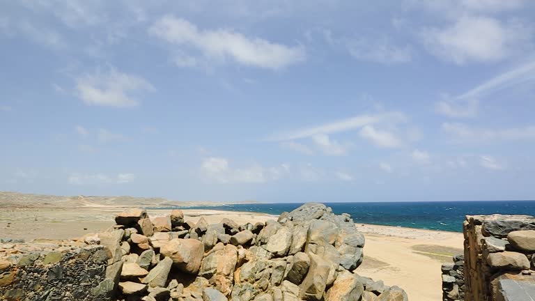 Beautiful historical view of ruins of Bushiribana gold smelter in national park on island of Aruba with Caribbean sea in background.