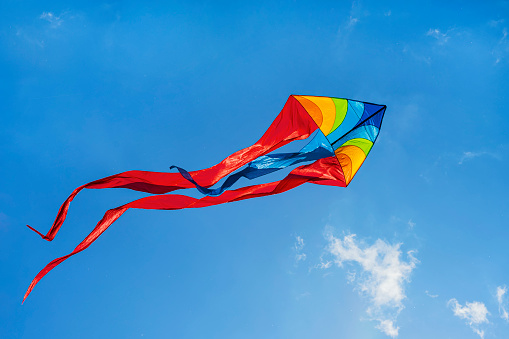 Bright Rainbow Kite closeup flying against blue sky