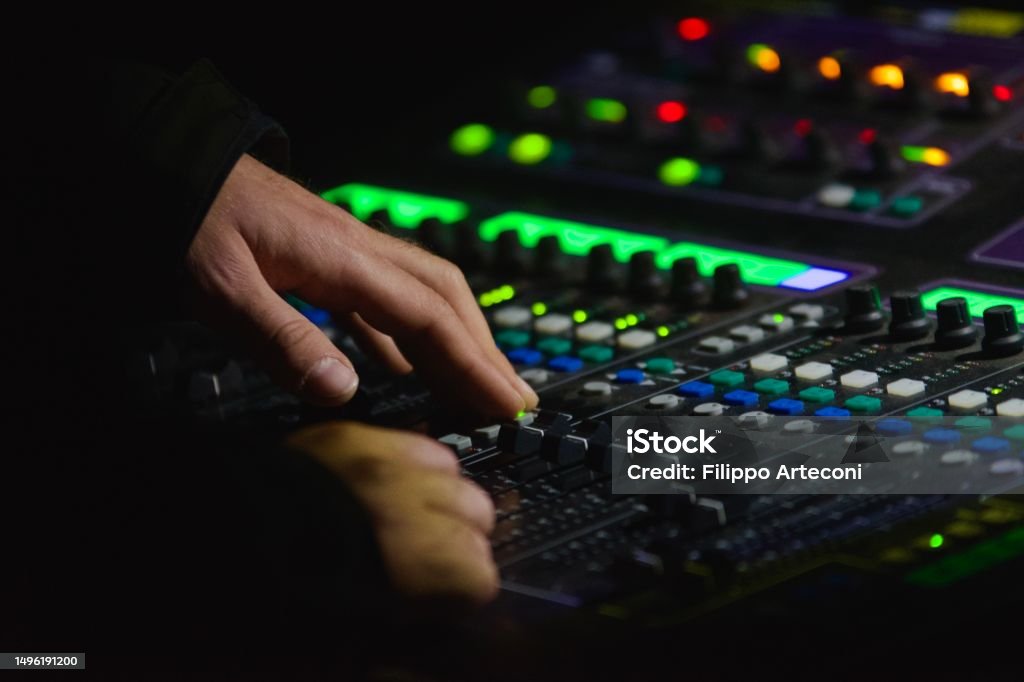 DJ, sound engineer at live concert DJ, sound engineer on mixer at live concert plays electronic music or adjusts parameters for musicians, night party event Electronic Music Stock Photo