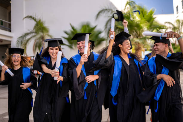 istock Young graduates friends celebrating while walking on graduation 1496191952