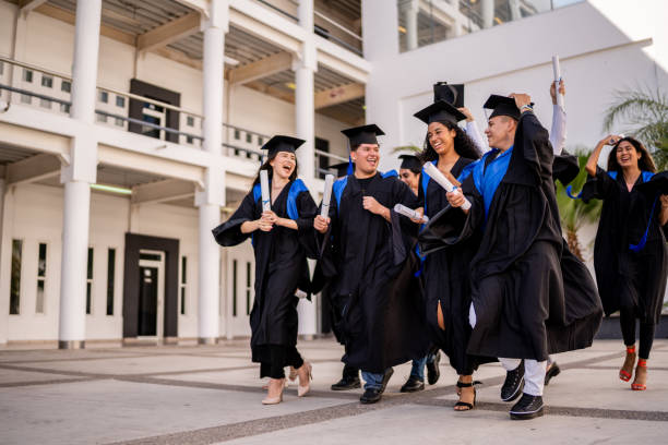 istock Young graduates friends celebrating while walking on graduation 1496191969