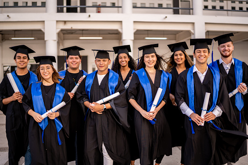 Portrait of young graduates with their diplomas on graduation