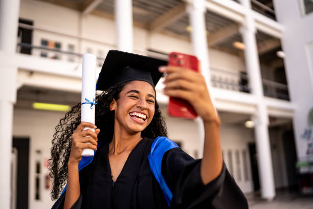 młoda kobieta robiąca sobie selfie z dyplomem ukończenia szkoły - czarni zdjęcia i obrazy z banku zdjęć