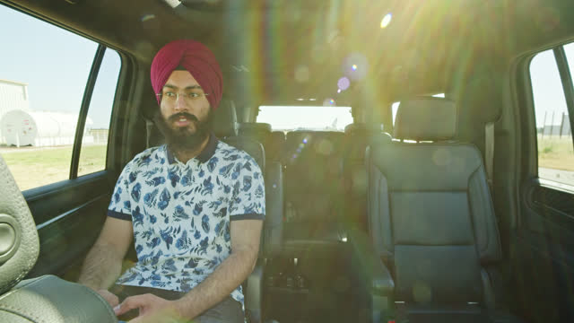 Indian Man Wearing Turban Sitting Inside a Car