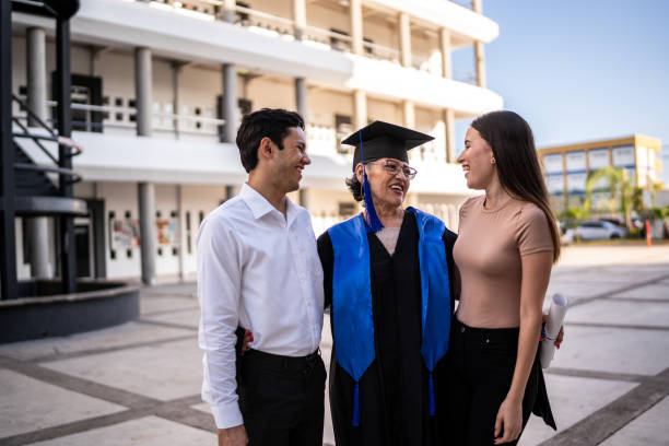 istock Senior graduate woman talking while embracing her daughter and son on her graduation 1496192549