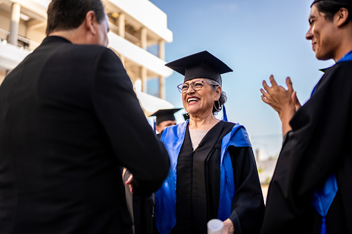 Senior graduate woman receiving her diploma on graduation