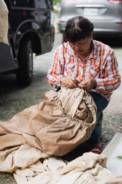 istock Female Tea farmer mending and repair work on a cloth bag 1496193831