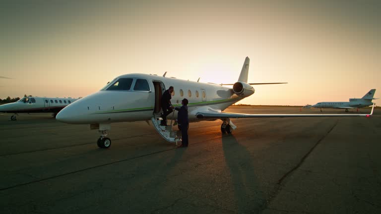 Descending Drone Shot of Wealthy Businessman Shaking Hands with Pilot as He Disembarks from Private Jet