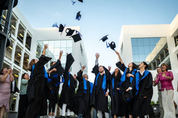 istock Young graduates throwing their mortarboard in the air while celebrating on graduation 1496195434