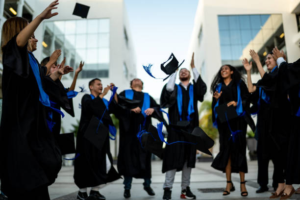 istock Young graduates throwing their mortarboard in the air while celebrating on graduation 1496195440