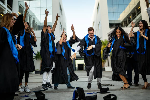 istock Young graduates throwing their mortarboard in the air while celebrating on graduation 1496195443