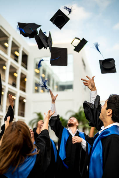 istock Young graduates throwing their mortarboard in the air while celebrating on graduation 1496195462