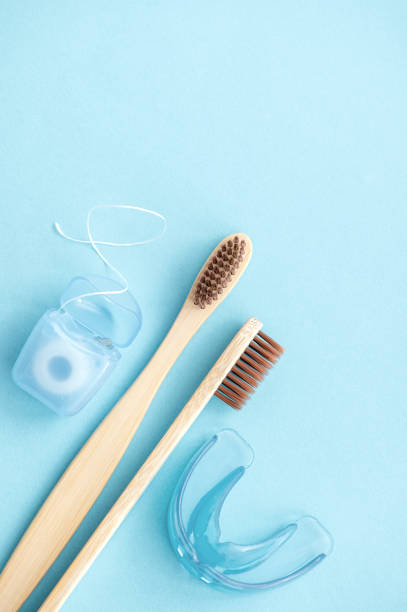 istock Various dental care tools on a blue background. Bamboo toothbrushes, dental floss, mouth guards. vertical photo 1496195467