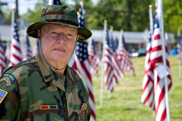 istock Vietnam War Combat Veteran among Flags looking at camera 1496195591
