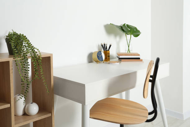 istock Comfortable workplace with white desk near wall indoors 1496197439