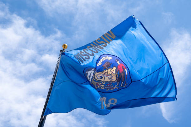 istock Wisconsin state flag blowing in the wind against a blue sky 1496199318