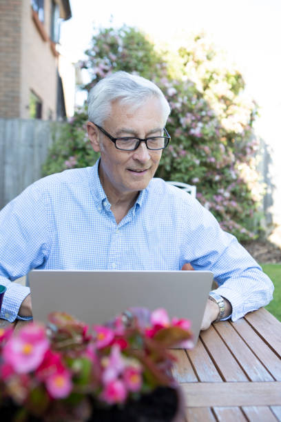 istock Mature man using a laptop in the garden 1496200123