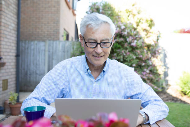 istock Mature man using a laptop in the garden 1496200743